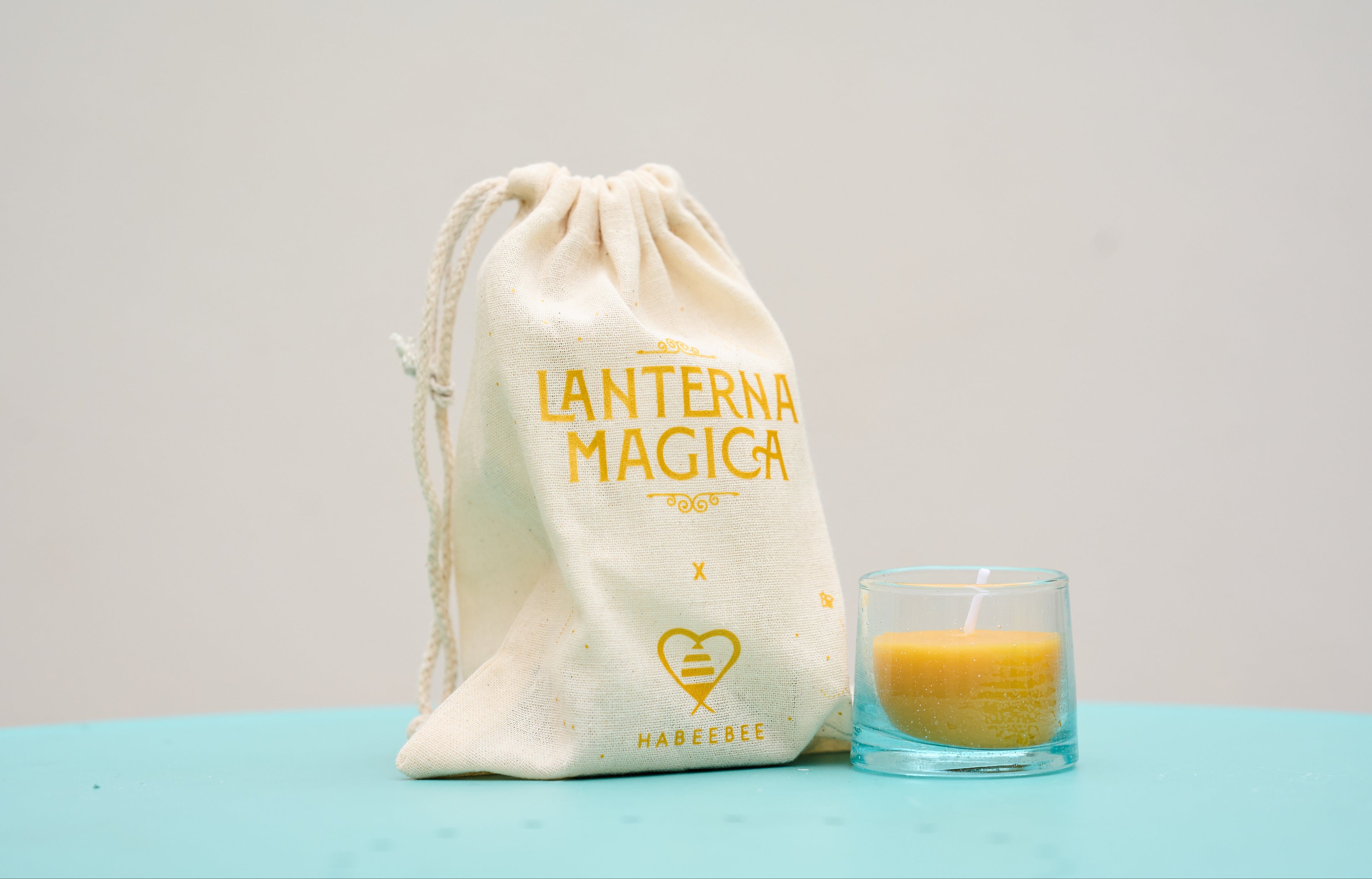 Bougie artisanale Habeebee dans un verre recyclé, accompagnée de son pochon « Lanterna Magica » – Une invitation à la poésie et à la lumière, fabriquée avec amour.
Handgemaakte Habeebee-kaars in een gerecycled glas, vergezeld van het zakje "Lanterna Magica" – Een poëtisch en lichtgevend gebaar, met liefde gemaakt.
Handmade Habeebee candle in a recycled glass, paired with the “Lanterna Magica” pouch – A poetic and luminous gift made with care.